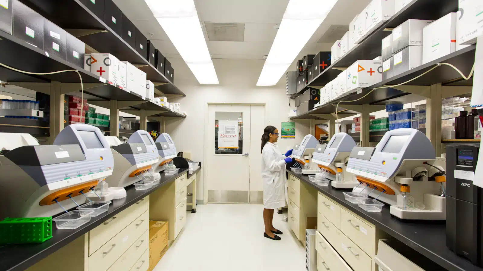 Profesional de laboratorio trabaja con analizadores clínicos durante el procesamiento de muestras.